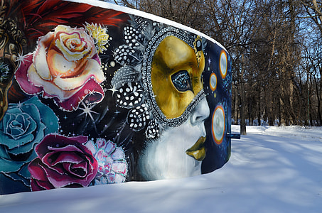 woman in masquerade wall painting near trees during daytime thumbnail