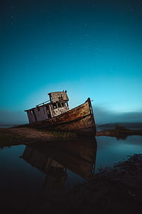 brown and white wooden boat on body of water thumbnail
