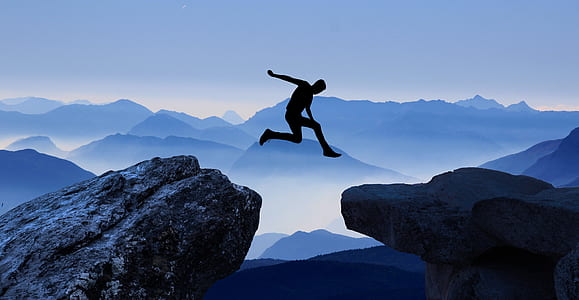 man jump from tip of mountain to another mountain thumbnail