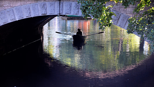 person riding paddle boat under bridge thumbnail