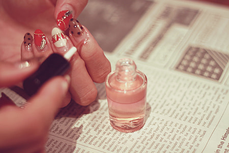 shallow focus photography of nail polish bottle on top of newspaper thumbnail