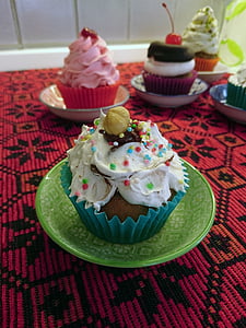 cupcake topped with sprinkles on top of green saucer thumbnail