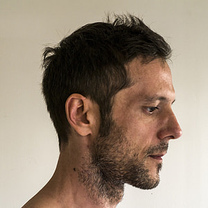 man standing near white wall thumbnail