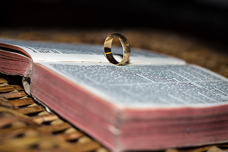 gold-colored ring on opened Bible selective focus photo thumbnail