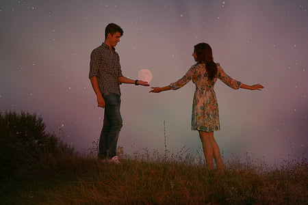 man wearing grey dress shirt facing woman wearing multicolored floral dress thumbnail