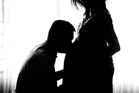 silhouette photo of man kissing belly of woman thumbnail