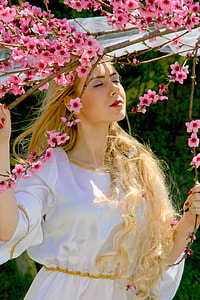 woman in white dress holding branch of Cherry Blossom tree thumbnail