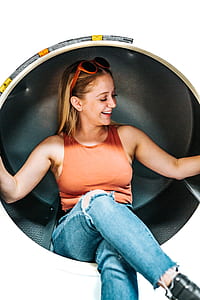 woman in blue jeans sitting on round wall thumbnail