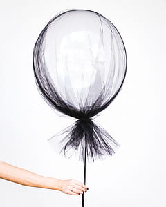 person's hand holding floating balloon thumbnail