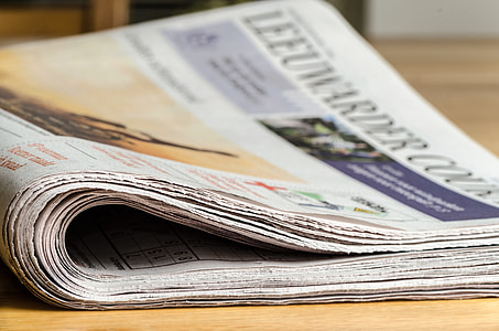 newspaper on brown wooden tab;e thumbnail