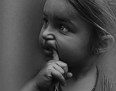 grayscale photography of a girl biting her finger thumbnail