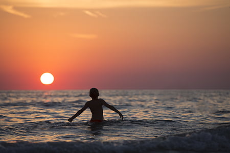boy on body of water during sun set thumbnail