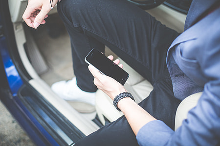Man Holding iPhone in His Car thumbnail