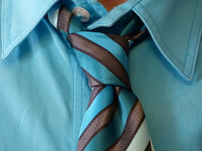 person wearing teal shirt and stripe necktie thumbnail
