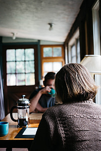 photo of a woman in black sweater sitting in front of a man in blue crew-neck shirt thumbnail