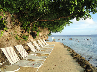 white sun loungers beside body of water thumbnail