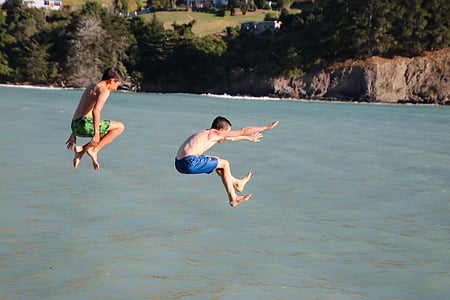 two boys jumping on body of water thumbnail