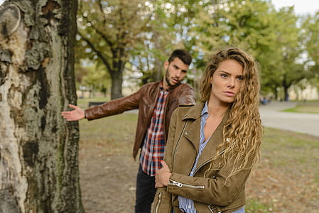 Woman And Man Wearing Brown Jackets Standing Near Tree thumbnail