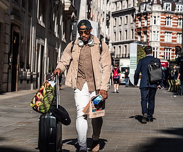 man walking while holding his travel luggage thumbnail