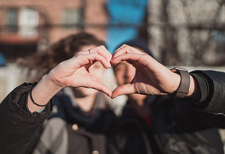 selective focus photography of man and woman doing heart sign thumbnail