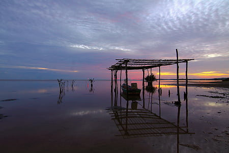 canoe on shore during golden hour thumbnail