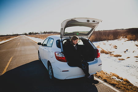 woman sitting on car luggage compartment thumbnail