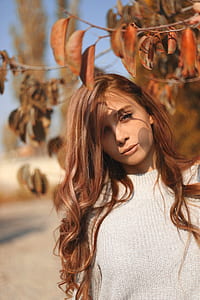 woman under brown leaf tree thumbnail
