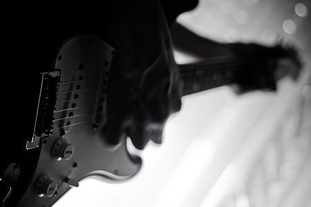 grayscale photo of man playing electric guitar thumbnail