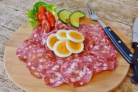 sliced eggs, cucumber, ham, and tomatoes served on brown plate thumbnail