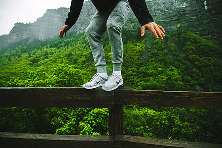 man standing on rail and mountain at distance thumbnail