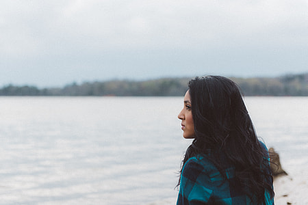 shallow focus photography of woman facing body of water thumbnail