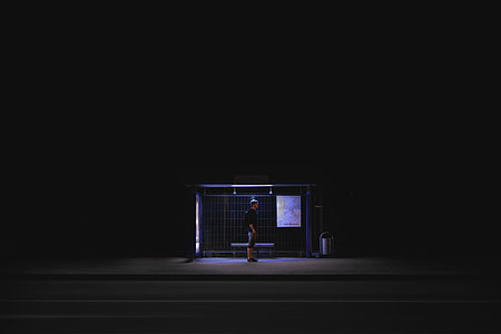 man in black shirt standing on waiting shed thumbnail