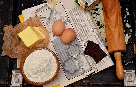 butter, flour, egg, and rolling pin on black surface thumbnail
