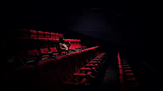 person sitting on red cinema chair thumbnail