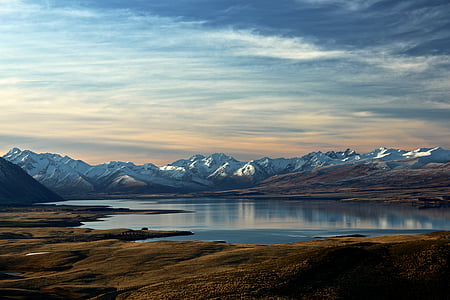 body of water near snow-covered mountains thumbnail