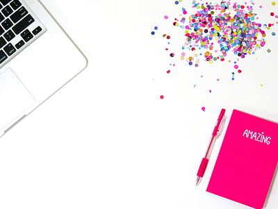 gray laptop computer, pink notebook and click pen on white surface thumbnail