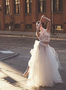 woman in dancing gesture on gray pavement near building thumbnail