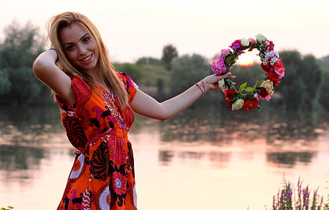 woman in red dress holding floral headband during daytime thumbnail