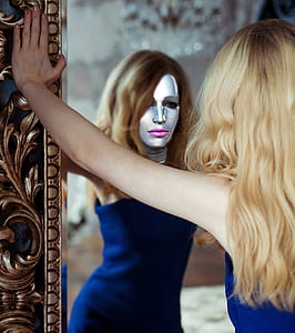 woman wearing blue dress leaning on mirror thumbnail