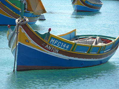 yellow, blue, and brown wooden row boat on body of water thumbnail