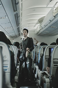 man walking in isle of plane thumbnail