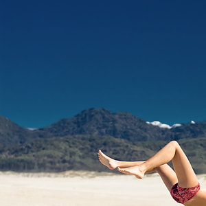 person with pink and black underwear flipping on white sand under blue sky thumbnail