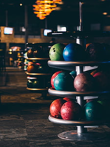 selective focus of assorted-color bowling balls on rack thumbnail