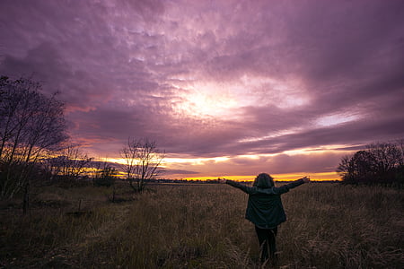 woman standing on green grass field thumbnail