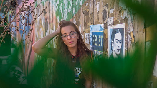 woman wearing jersey shirt leaning on brown wall with hand on head thumbnail