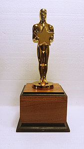 man holding star gold trophy on brown wooden base thumbnail