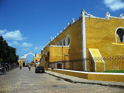 black car parked beside yellow building thumbnail