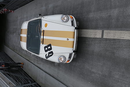 white car passing through asphalt road thumbnail