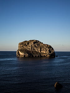 rock formation on the body of water thumbnail