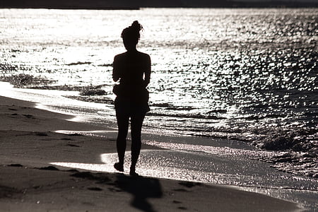 silhouette of woman walking on seashore thumbnail
